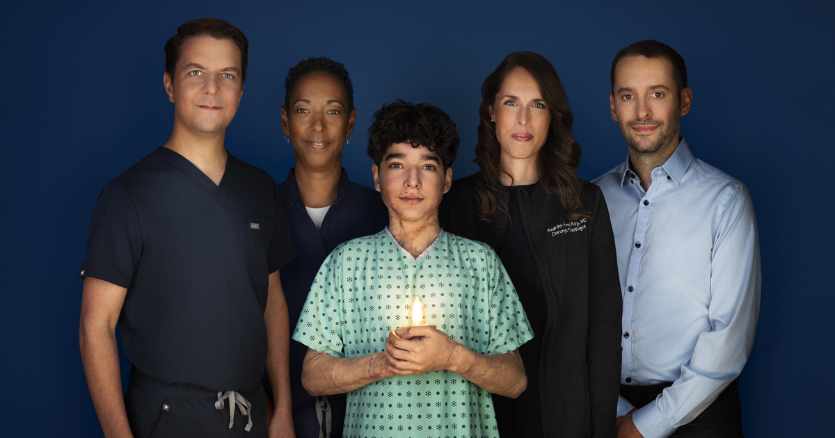 Baptiste, 16 ans, porte une jaquette d’hôpital, tient une ampoule allumée dans ses mains, entouré de ses soignants.